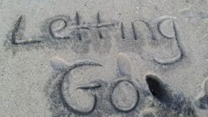Letting go written in sand